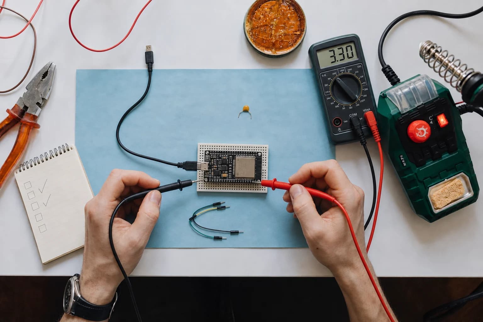 ESP32 development board being checked with multimeter probes on a practical electronics workbench