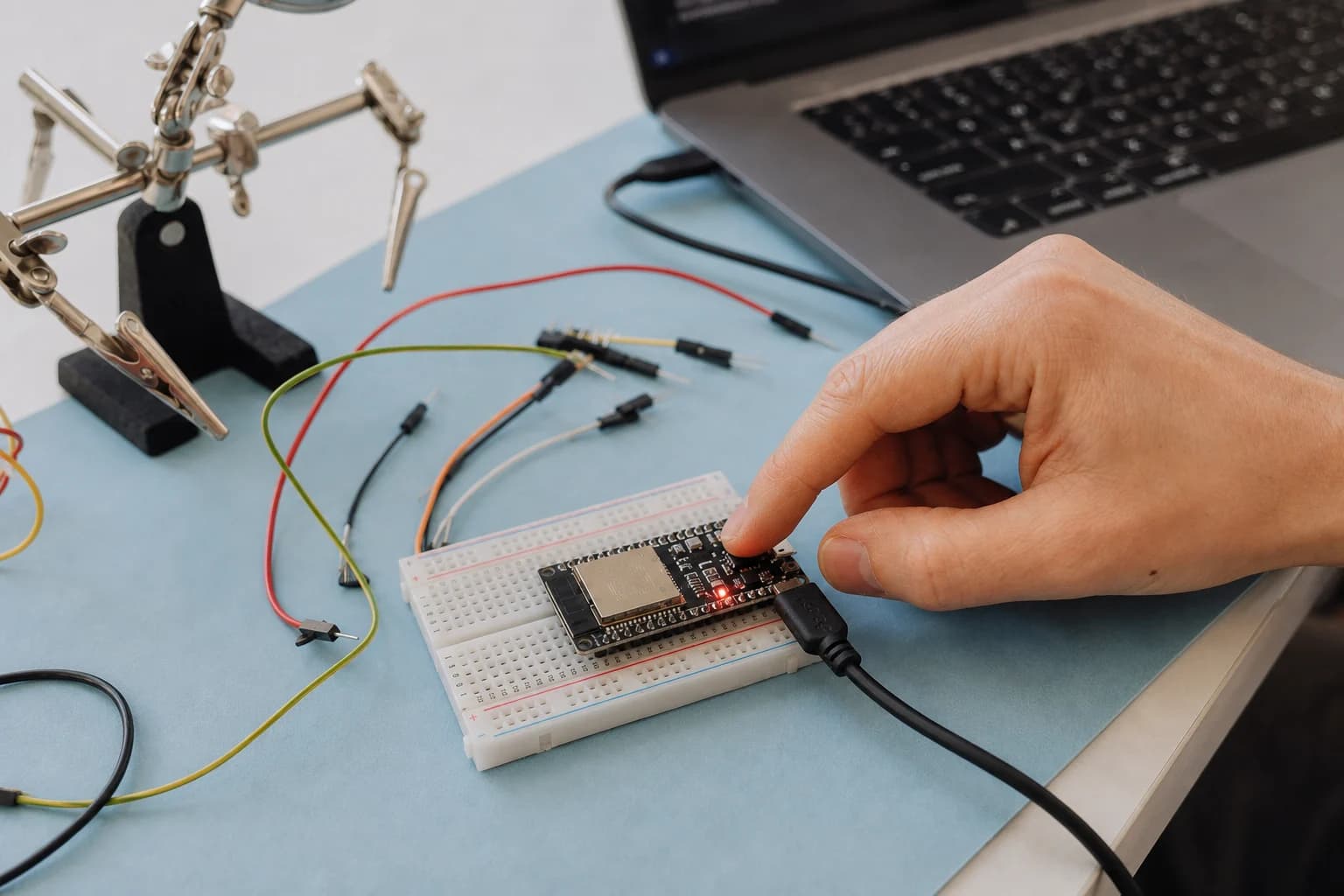 A user holds an ESP32 board on a breadboard while connecting USB to troubleshoot firmware flashing.