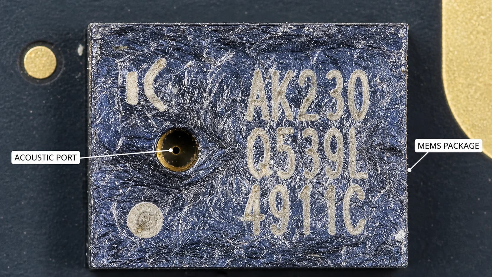 Macro photo of a MEMS microphone package showing its acoustic port and package marking