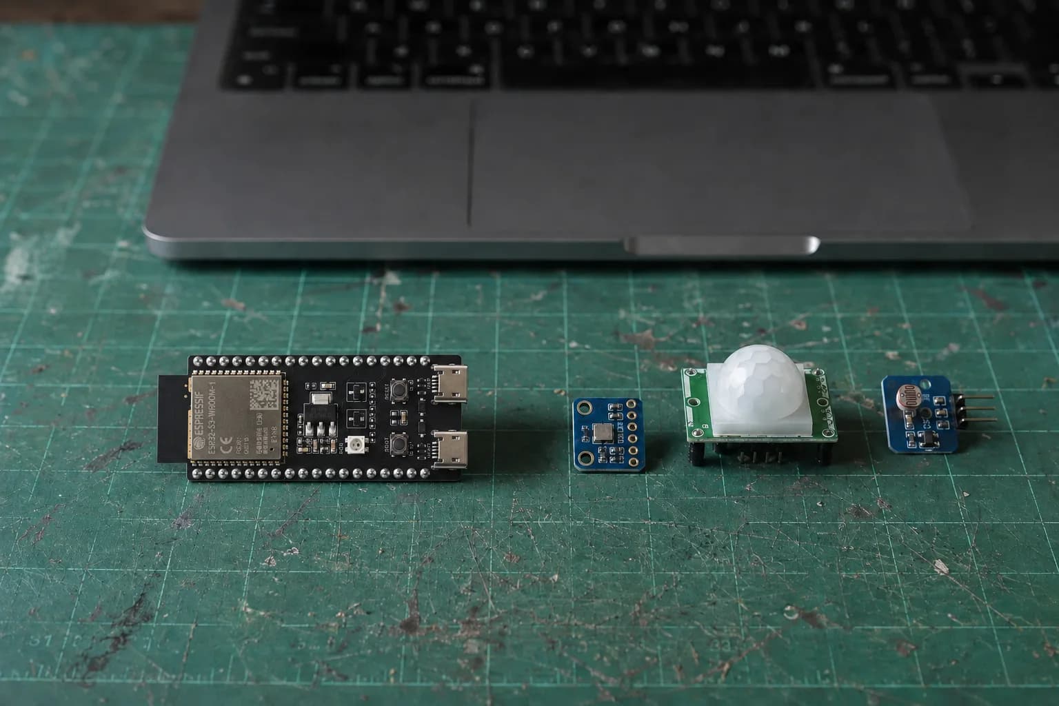 An ESP32-S3-DevKitC-1 beside a BME280 breakout, PIR sensor, and temperature-humidity sensor module.