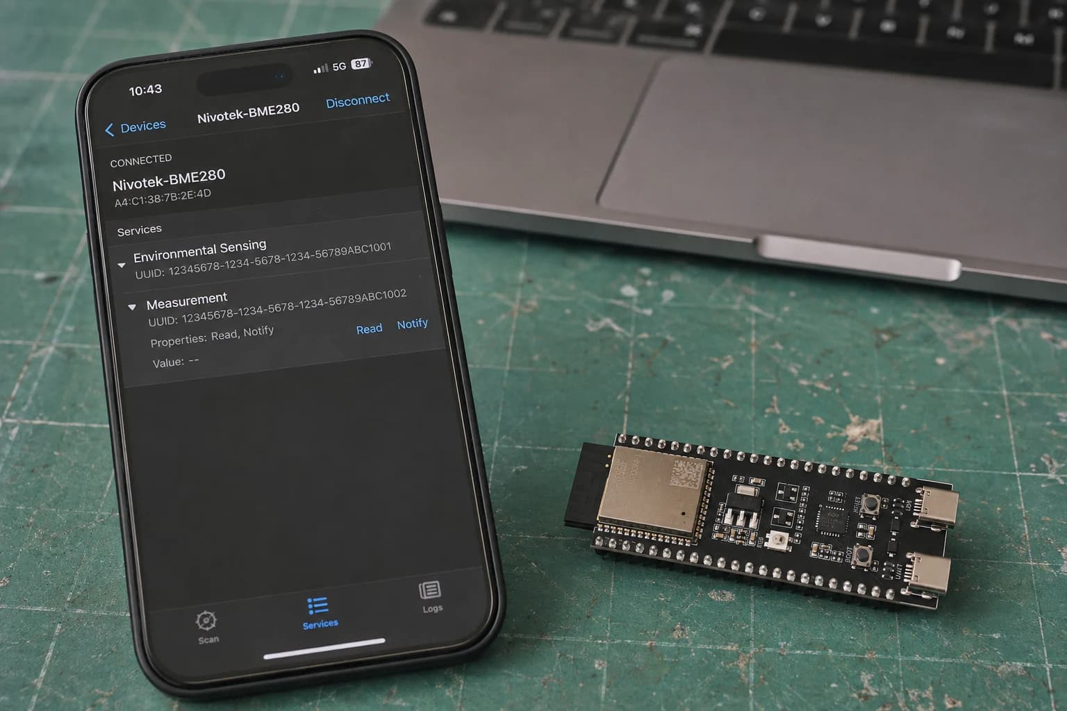 Ứng dụng GATT trên điện thoại hiển thị custom service và characteristic của ESP32-S3 cạnh MacBook Pro.
