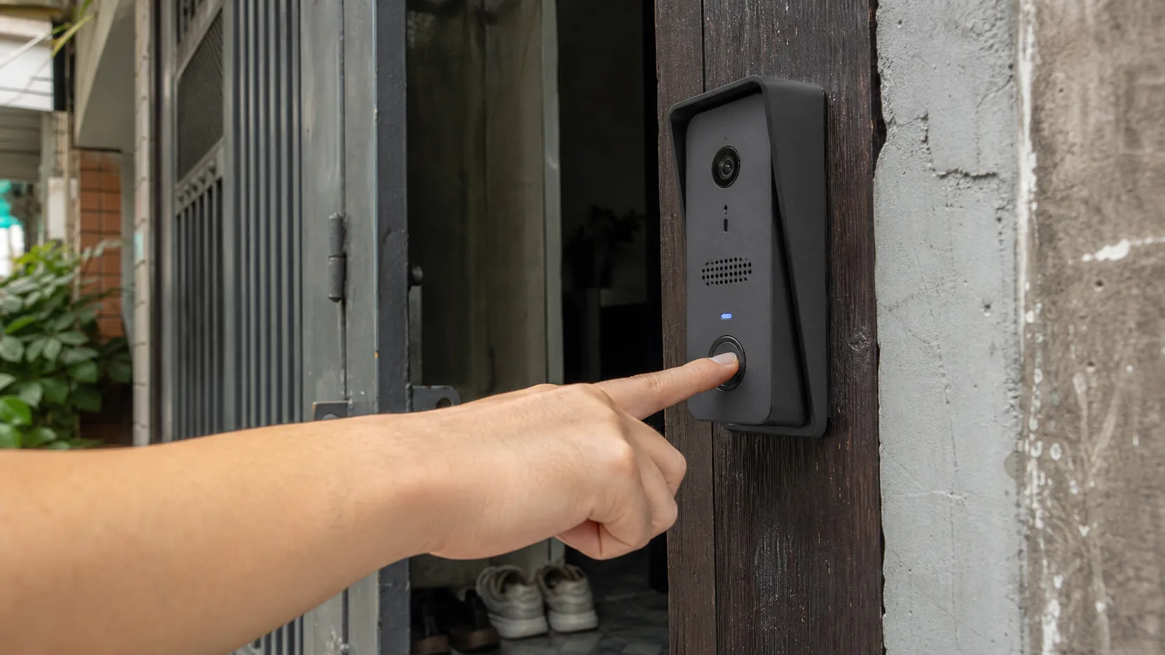 A wired privacy-first video doorbell installed beside the entrance of a Vietnamese townhouse
