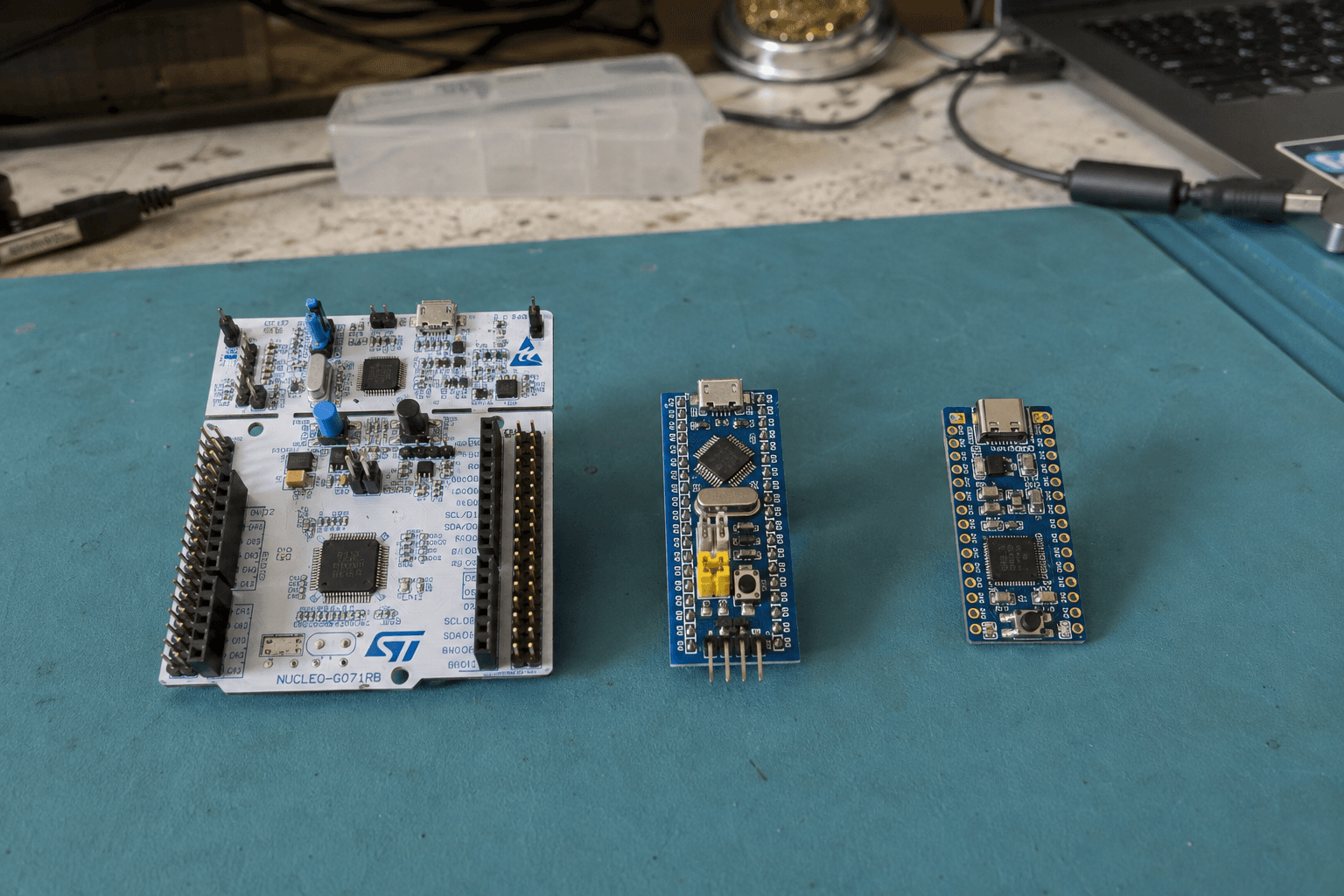 Ba board phát triển STM32 gồm Nucleo-G071RB, một board STM32F103 kiểu Blue Pill và một board STM32 nhỏ đặt cạnh nhau.