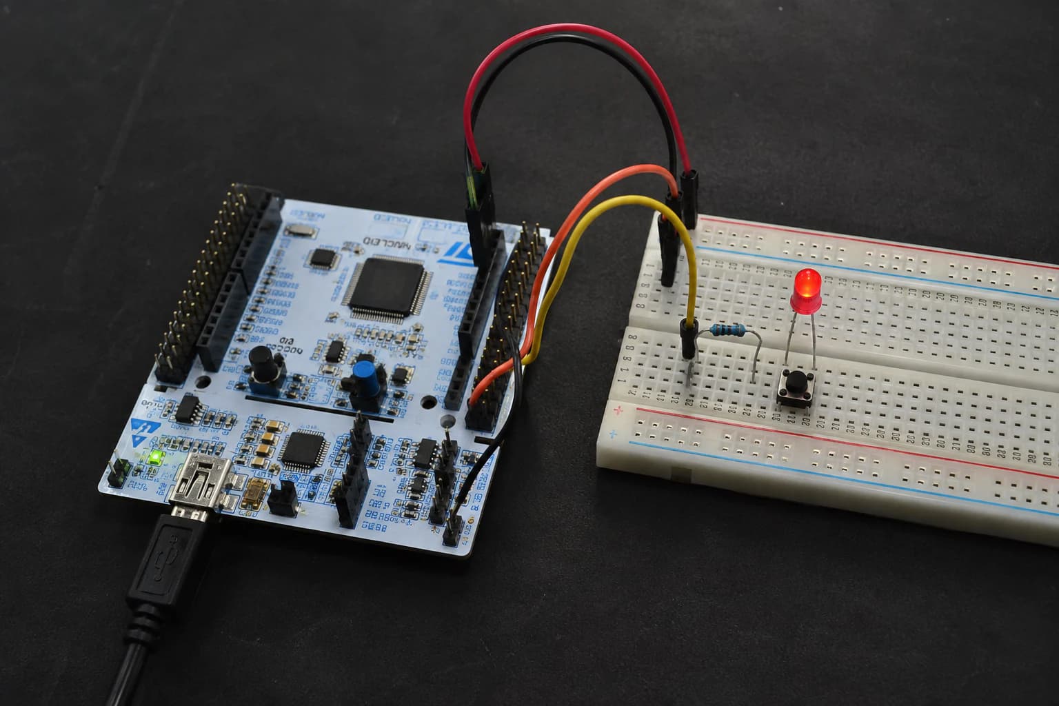 Board STM32 Nucleo điều khiển LED trên breadboard trong một phép thử timer cạnh laptop và oscilloscope.
