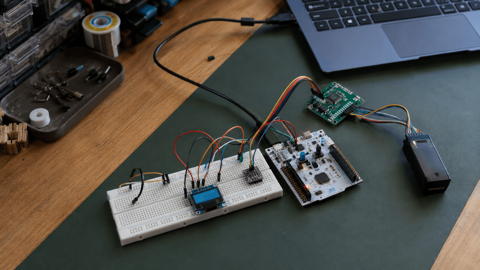 STM32 Nucleo board connected to UART, I2C, and SPI test hardware on an electronics workbench